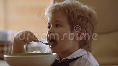 宝宝吃，宝宝吃.. 小家伙在喝粥。 有趣的孩子吃牛奶粥。